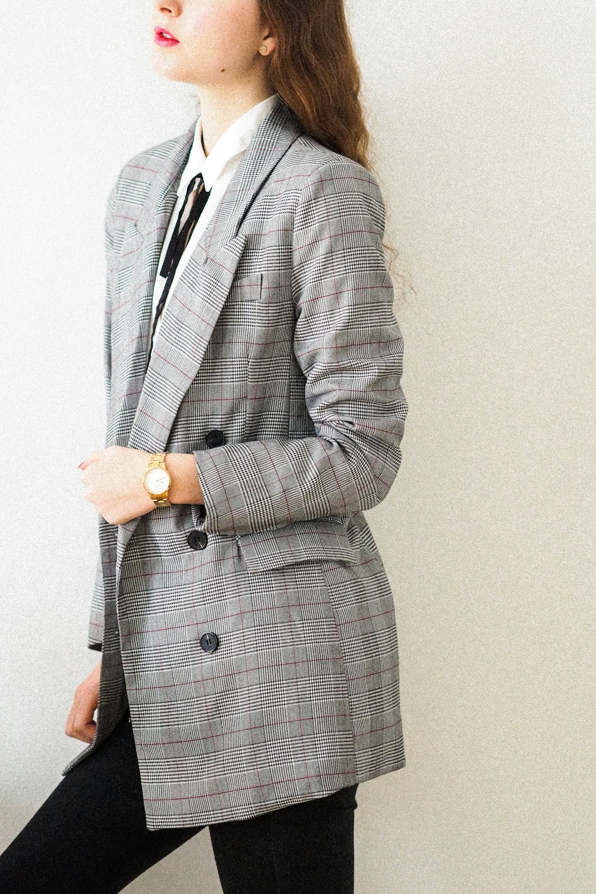 Frau im grauen Blazer mit Glencheck-Muster